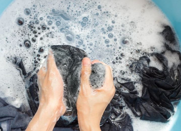 Hand washing lingerie in cold soapy water.