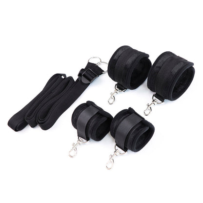 Under-the-bed restraint system with soft black cuffs and adjustable straps.