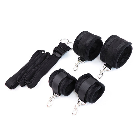 Under-the-bed restraint system with soft black cuffs and adjustable straps.
