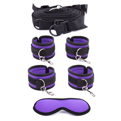 Under-mattress bed restraint system in purple and black with four padded cuffs and a matching textured blindfold.