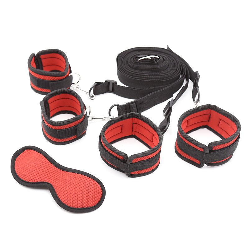 Under-mattress bed restraint system in red and black with four padded cuffs and a matching textured blindfold.