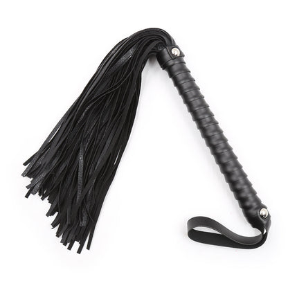 Black faux leather bondage whip with ribbed handle and wrist strap on a white background. 