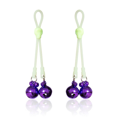 Glow-in-the-dark adjustable nipple bells with purple jingle bells and skull accent.