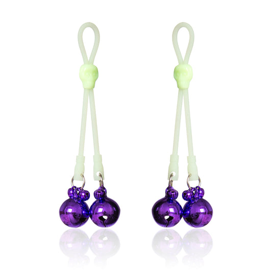 Glow-in-the-dark adjustable nipple bells with purple jingle bells and skull accent.