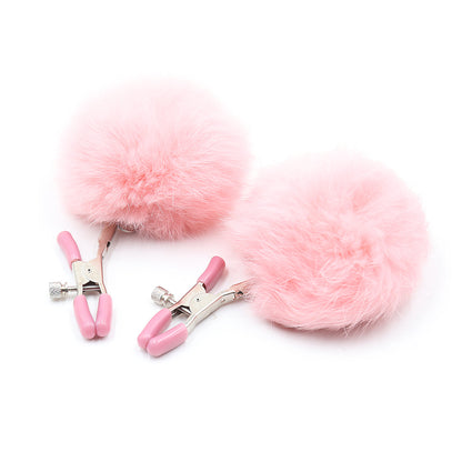 Pom-pom nipple clamps in pink with adjustable tension and rubber-tipped ends. 