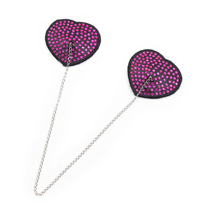 Pink heart-shaped rhinestone nipple pasties with connecting chain on a white background. 
