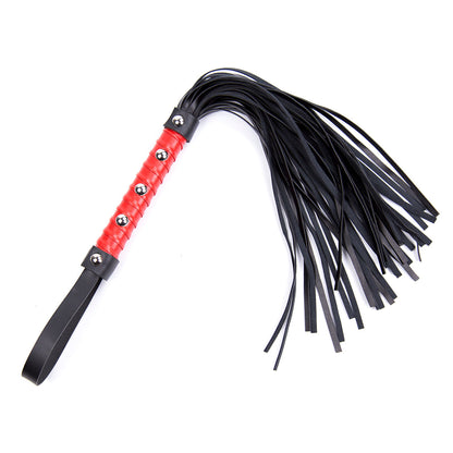 Red studded handle flogger with black faux leather tails and wrist loop on white background.