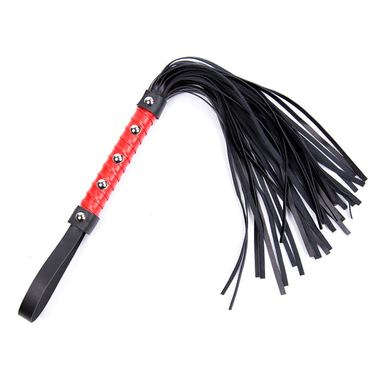 Red studded handle flogger with black faux leather tails and wrist loop on white background.